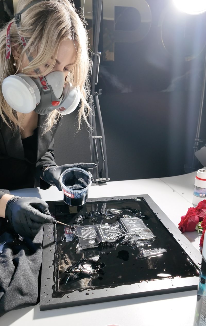 Natalie Pikul arbeitet mit Halbmaske und Nitrilhandschuhen an einem Resin-Bild